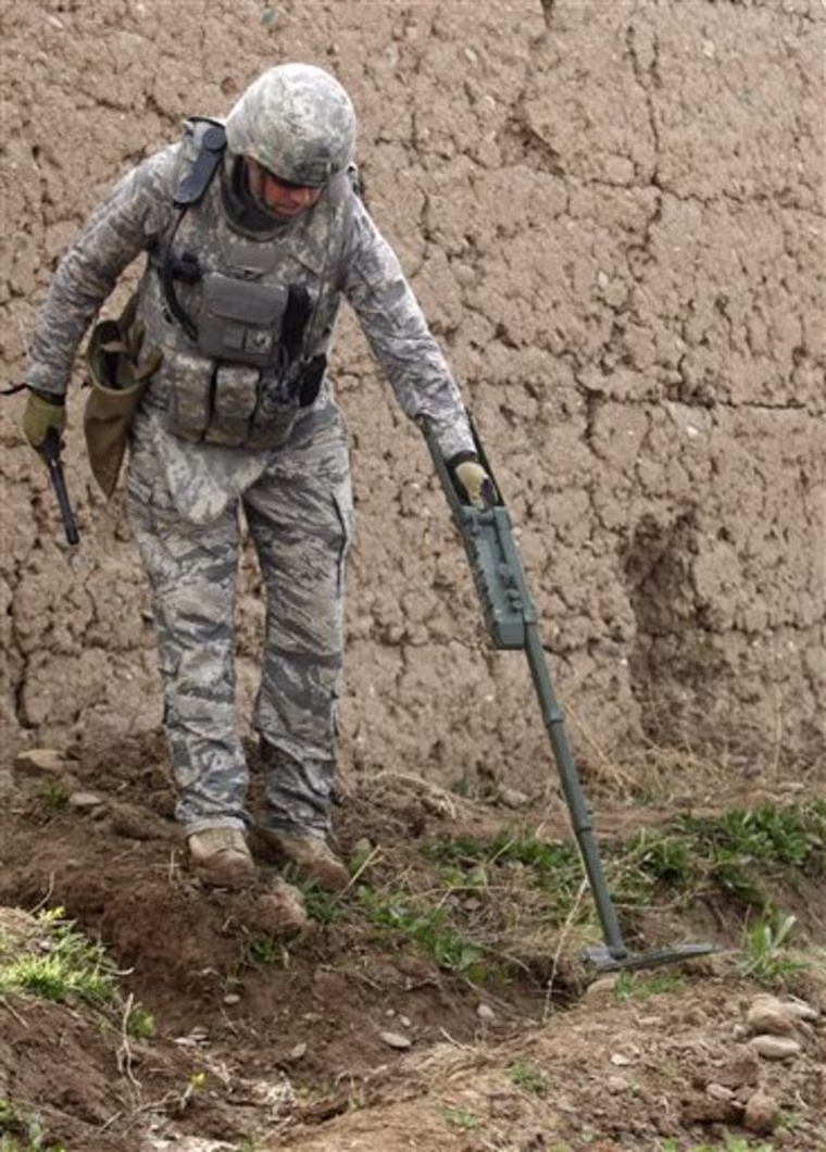 U.S. Air Force Staff Sgt. Joshua  Rickert, from San Antonio, Texas, member of an Explosive Ordnance Disposal unit, checks for concealed bombs in the Badula Qulp area, west of Lashkar Gah in Helmand province, southern Afghanistan, Tuesday, Feb. 23, 2010. (AP Photo/Pier Paolo Cito)